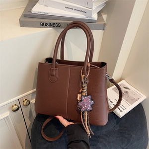 Minimalist large brown tote bag in pebbled leather with a cute bear charm pendant