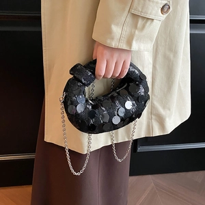 Close-up of black sequined knot evening bag with metallic chain and reflective finish