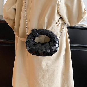 Detail shot of black sequin knot bag with metallic finish and silver chain shoulder strap
