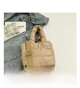 Detail view of khaki down quilted handbag with adjustable strap and reinforced handle