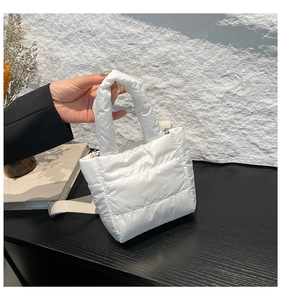 Detail of white quilted puffer handbag with adjustable shoulder strap for versatile styling