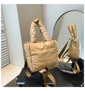 Detail of champagne gold puffer bag with quilted texture and detachable wide strap