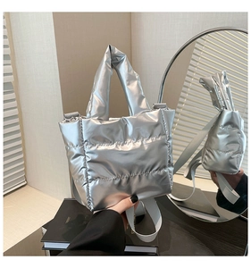 Detail of silver quilted handbag showing mirror finish texture and adjustable strap