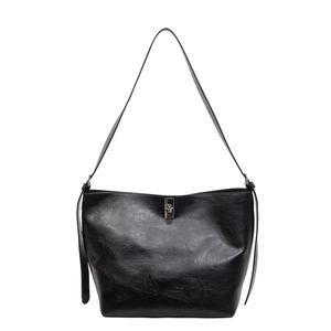 Minimalist black faux leather tote bag with silver twist lock and slim shoulder strap