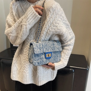 Elegant blue tweed quilted crossbody chain bag styled with a white cable knit sweater