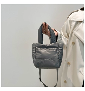 Gray quilted puffer handbag with adjustable shoulder strap and metallic buckle detail