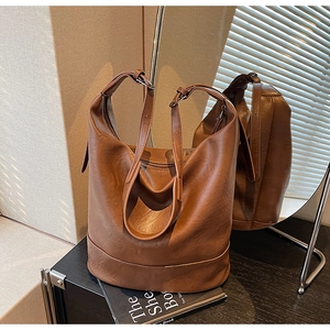 Detail of adjustable strap and smooth leather texture on a large dark brown tote bag