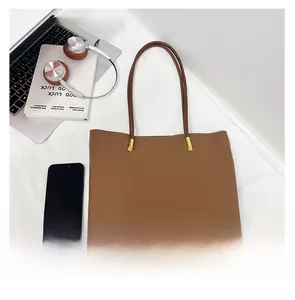 Détail du sac cabas en cuir grainé marron foncé avec attaches dorées et fines poignées