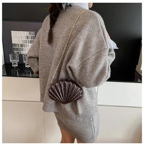 Détail de la texture ondulée sur un sac bandoulière marron métallisé en forme de coquille