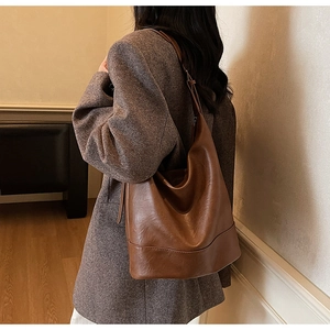 Detail of a large brown leather hobo bag showing spacious capacity and smooth texture