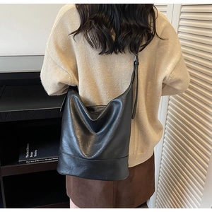 Detail of soft black leather tote bag with adjustable strap and reinforced stitching