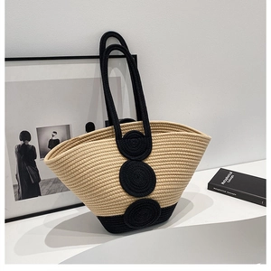 Close-up of a handmade woven tote bag with a two-tone beige and black minimalist design