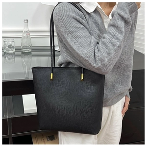 Détail du sac cabas noir en cuir grainé avec d'élégantes finitions en métal doré brillant