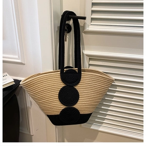 Detail of hand-woven tote bag showing beige and black contrast textures and woven patches
