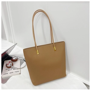 Gros plan détaillé du cabas en cuir grainé marron avec boucles métalliques dorées