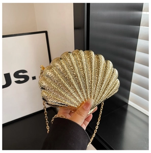 Vue détaillée du sac de soirée doré en forme de coquille avec texture martelée et chaîne