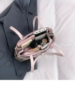 Detail view of large pink plaid boston bag showing spacious interior compartments