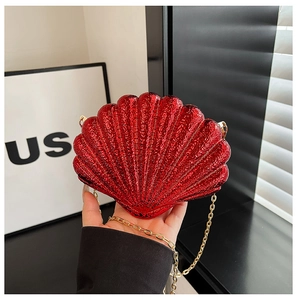 Gros plan détaillé d'un sac de soirée en forme de coquillage rouge à paillettes dorées