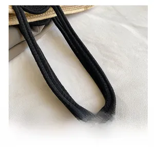 Detailed view of the comfortable black shoulder strap and woven texture on this tote bag
