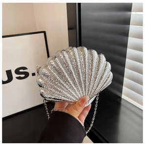 Vue détaillée du sac de soirée argenté en forme de coquille avec texture martelée