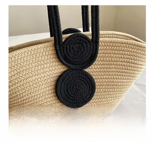 Detailed close-up of woven straw handbag featuring black circular decorative patterns
