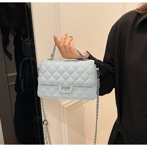 Close-up of light blue quilted crossbody bag with silver twist-lock and chain strap
