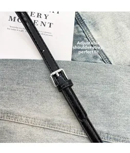 Detail showing adjustable black leather strap with silver metal buckle and stitching