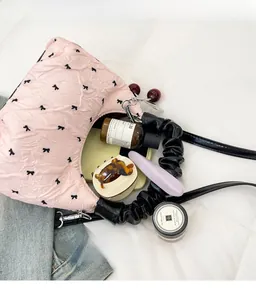 Top view of pink bow-print handbag showing spacious interior with personal essentials