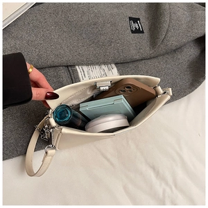 Vista interna che mostra la capacità della borsa in pelle beige per trucco e cellulare