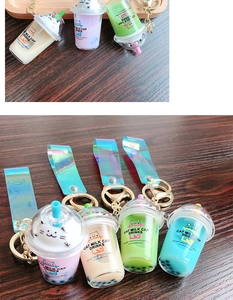 Detail of creative cat milk tea cup keychain with laser strap and liquid quicksand finish