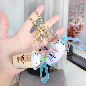 Quicksand bubble tea keychain featuring a cat milk cap design with pink liquid and glitter