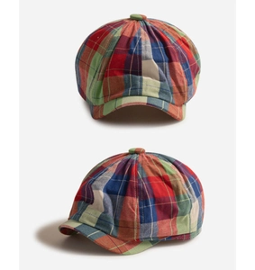 Detailed view of the checkered cotton newsboy cap with vibrant plaid patterns and top button