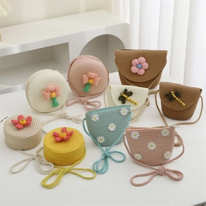 Detail of colorful woven straw bags for girls with 3D floral and dragonfly decorations