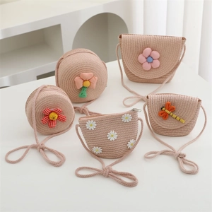 Detailed close-up of woven straw crossbody bags with floral embroidery and dragonfly decor