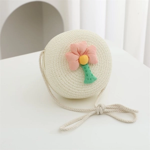 Detailed close-up of beige round straw crossbody bag with pink 3D fabric flower decoration