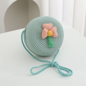 Detailed macro view of mint blue woven straw bag with handmade floral applique design