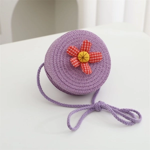 Close-up of woven lavender straw bag featuring a red checkered fabric flower detail