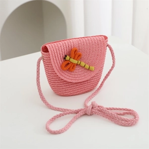 Detail of pink woven straw bag with 3D orange dragonfly charm and thick cord strap