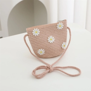 Close-up of pink woven straw bag featuring white daisy appliqués and a zipper closure