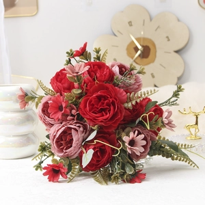 Detailed view of red and pink artificial peony bouquet with green leaves and berries