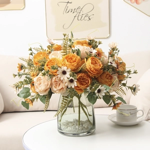 Elegant artificial peony bouquet with white daisies in glass vase with white stones
