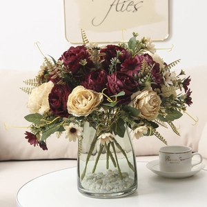 Close-up of elegant silk peony bouquet in glass vase with stones for home decoration