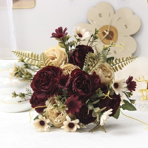 Detail of faux burgundy peonies and daisies in a luxury artificial flower arrangement
