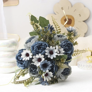 Detail of elegant blue and gray peony silk flower arrangement with green fern leaves
