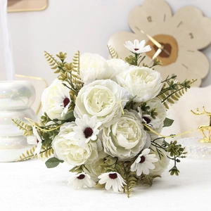 Detailed view of artificial white roses and daisies with lush green fern leaves for decor
