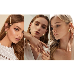 Detailed view of large gold teardrop earrings with mirror-like metallic finish on models