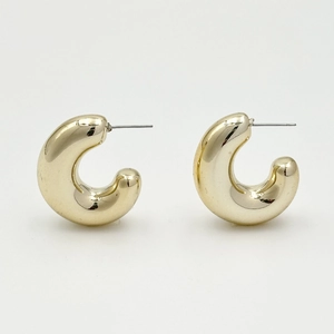 Minimalist thick golden hoop earrings with high-gloss metallic finish on white background