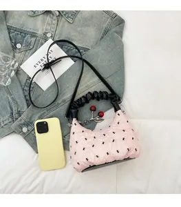 Pink pleated dumpling bag featuring black polka dots and a red cherry charm detail