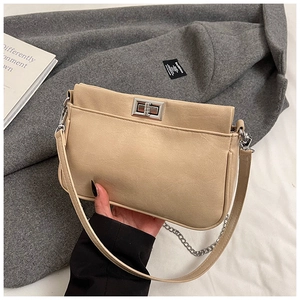 Dettaglio borsa beige rettangolare con chiusura a scatto argento e pelle opaca