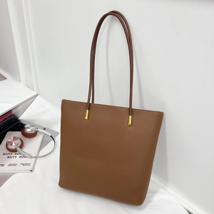 Sac cabas marron en cuir grainé pour femme présenté avec un ordinateur dans un bureau